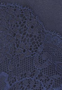 Marineblauer Stoff mit filigraner Spitze im Blumenmuster. Glatte Oberfläche mit einem kontrastierenden offenen Gewebe und gewellten Kanten.