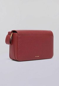 Borsa a tracolla rossa in pelle con una superficie liscia, forma rettangolare e una maniglia laterale. Presenta un logo discreto sul davanti.