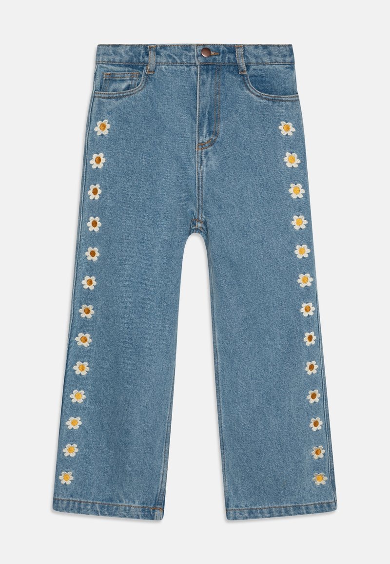 Pantalon large en denim bleu avec des marguerites blanches et jaunes brodées tout le long des coutures extérieures des deux jambes.