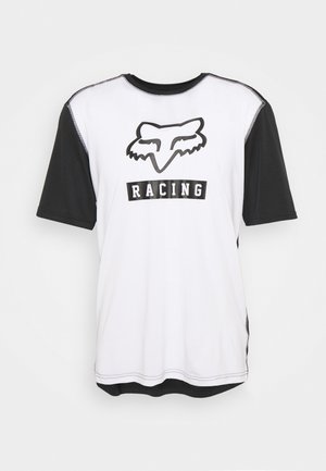 Korte mouwen t-shirt met een wit lichaam en zwarte mouwen. Bevat een logo van een vos en het woord "RACING" in vetgedrukte zwarte letters. Gemaakt van gladde stof.
