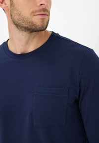 Navyblauwe langemouwen t-shirt van gestructureerde stof, met een klassieke ronde hals en een klein borstzakje.
