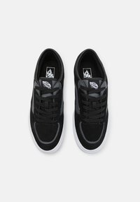 Svart semi-anilinerte sneakers med grå detaljer. Funksjoner inkluderer polstret krage, snøring og hvit gummisåle. Vans-logo på tungen.