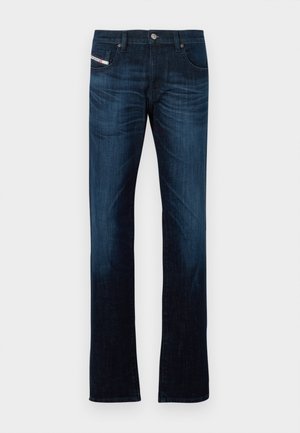 Jeans de perna reta azul escuro com bolsos frontais, passantes de cinto, fecho de botão e detalhes de desvanecimento sutis nas coxas e joelhos.