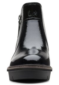 Bottine en cuir verni noir avec bout arrondi, fermeture éclair sur le côté et semelle épaisse avec détail de surpiqûres.