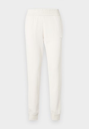 Pantalon de jogger crème en tissu doux, avec une taille et des poignets ajustés. Design simple sans motifs visibles ni ornements.