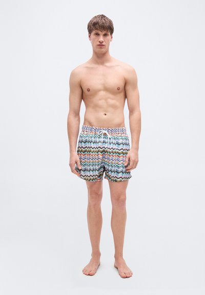 Shorts de bain avec un motif zigzag multicolore, dotés d'une taille élastique avec cordon de serrage, fabriqués en tissu léger.