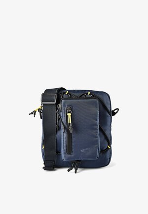 Kompakt skuldertaske i marineblå med flere lynlåslommer, justerbar sort rem og gule lynlåsvedhæng.