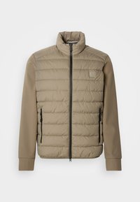 Veste matelassée beige avec un col montant et une fermeture éclair. Présente une texture matelass�ée à l'avant, des manches lisses et des poches latérales zippées.