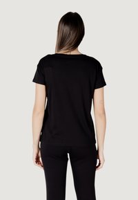 T-shirt nera a maniche corte realizzata in tessuto morbido, vestibilità comoda, scollatura rotonda e dettagli di cucitura minimi sul retro.