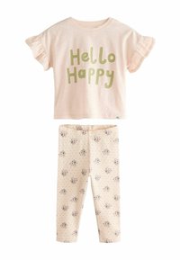 Világos rózsaszín t-shirt zöld "Hello Happy" felirattal és fodros ujjal, virágmintás leggingssel kombinálva, krém színben pöttyökkel.