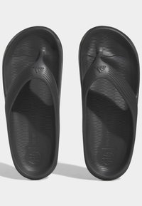Svarta flip-flops i strukturerad gummi. Har en snodddesign med en lätt båge, präglad logotyp och detalj med "END PLASTIC WASTE" på fotbädden.