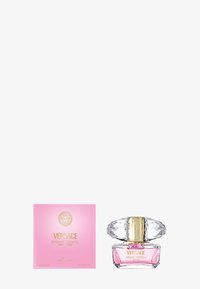 Versace Bright Crystal Parfüm, präsentiert in einer klaren Glasflasche mit einem goldakzentuierten Verschluss, rosa Flüssigkeit und einer rosa Schachtel mit goldener Schrift.