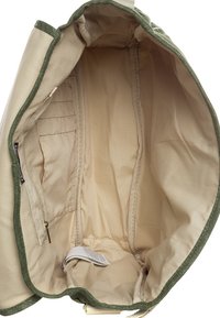 Interno della borsa in tela, tessuto beige con rifiniture verdi, presenta molteplici tasche e un scomparto con zip. Texture liscia, senza motivi visibili.