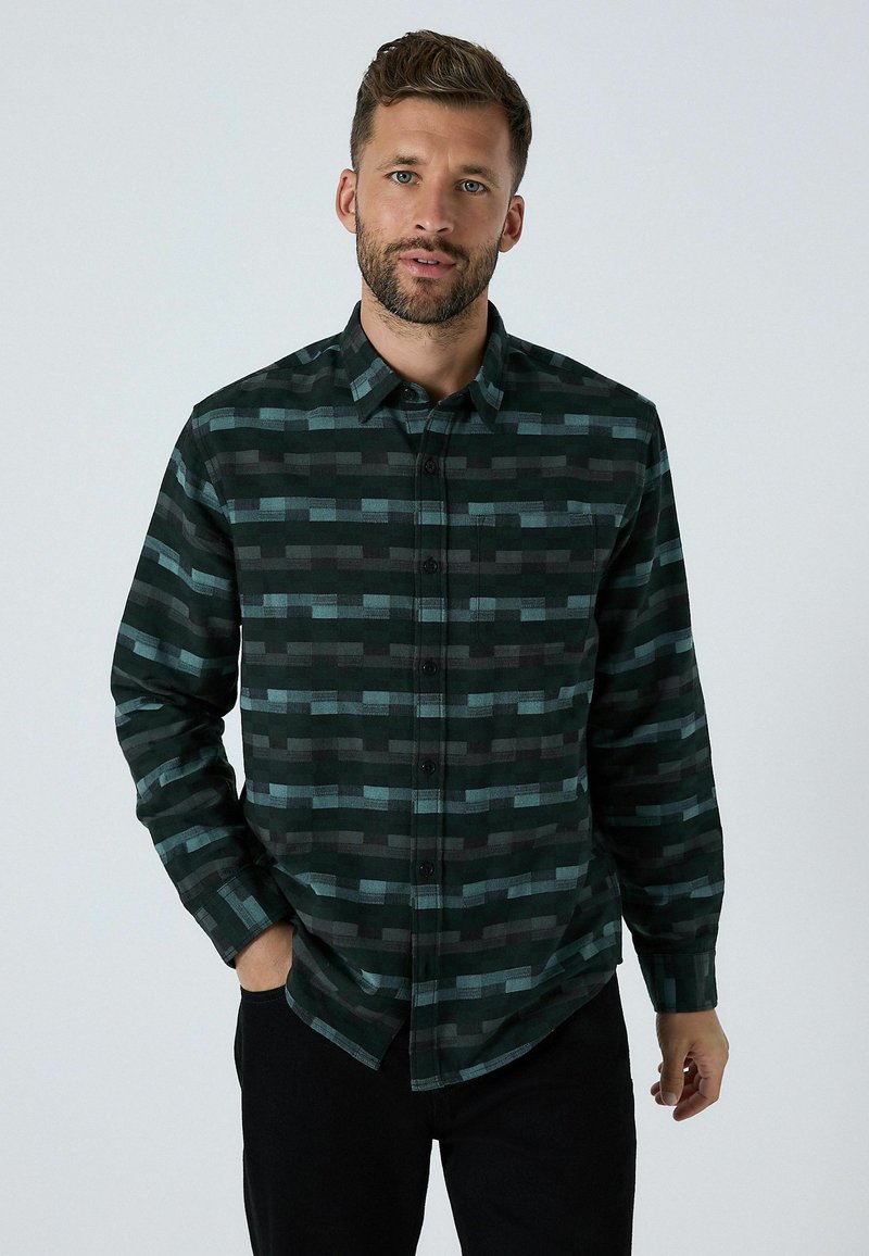 Vihreä ja musta ruudullinen nappipaita, jonka malli on rento. Paidassa on erilaisia suorakaiteen muotoisia kuvioita ja rintatasku.