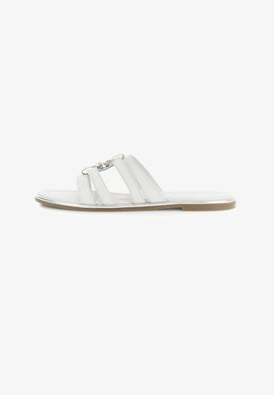 Sandalo piatto bianco con tre cinturini e dettaglio fibbia argento su sfondo bianco.