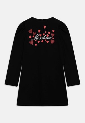 Czarna sukienka z długim rękawem, bufkami na ramionach, czerwonymi wzorami serc i logo „Moschino” w białym ręcznym piśmie na piersi.