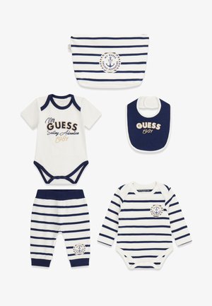 Ensemble de vêtements pour bébé rayé bleu marine et blanc comprenant des bodys, un pantalon, un bavoir et une pochette arborant le texte "My Guess Sailing Adventure 1987" et un logo ancre.