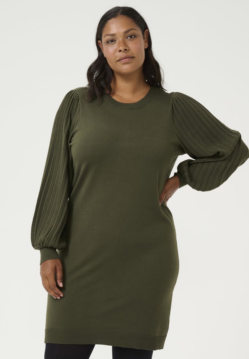 Robe en tricot verte avec des manches ballon côtelées et un col rond. Elle présente une coupe décontractée et un ourlet côtelé, offrant une texture douce.