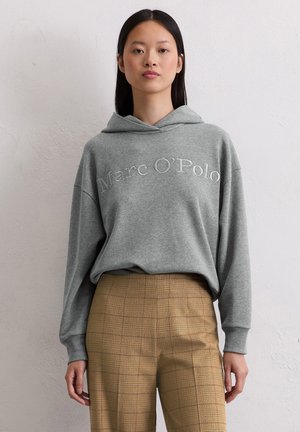 Sweatshirt à capuche gris avec nom de marque brodé, associé à un pantalon à carreaux. Tissu doux, coupe décontractée et épaules tombantes pour plus de confort.