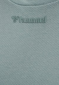 Hellgrüner, atmungsaktiver Stoff mit geprägtem hummel-Logo und stilisiertem Bienen-Emblem nahe dem Halsausschnitt.