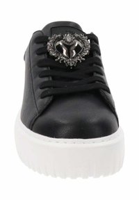Sneaker in pelle nera con suola piatta bianca spessa e lacci neri. Presenta un embellimento a forma di cuore argentato sulla linguetta.