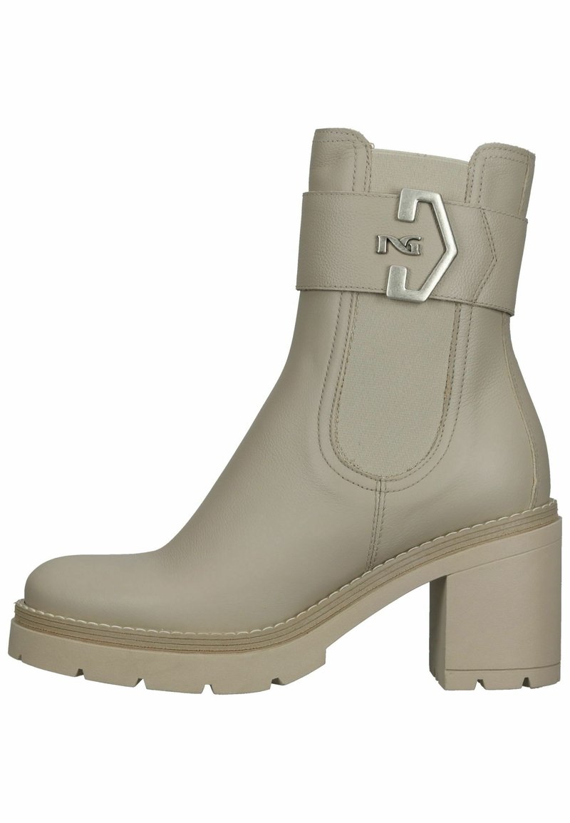 Botte en cuir beige mi-mollet avec talon épais, panneau latéral élastique, sangle décorative et détail de boucle argentée sur le côté extérieur.