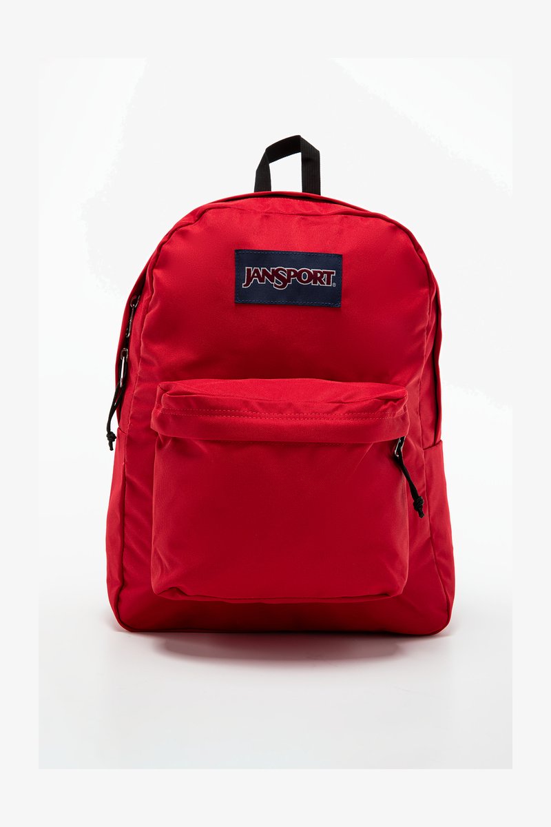 Sac à dos en nylon rouge avec une poche avant, des bretelles réglables et une poignée supérieure. Présente un patch de logo Jansport bleu. Texture lisse, forme arrondie.