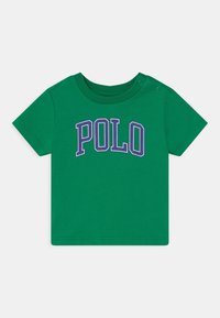 Zelené tričko s krátkým rukávem vyroben é z bavlny, na přední straně s fialovým grafickým potiskem "POLO" a zapínáním na patentky na rameni pro snadné oblékání.