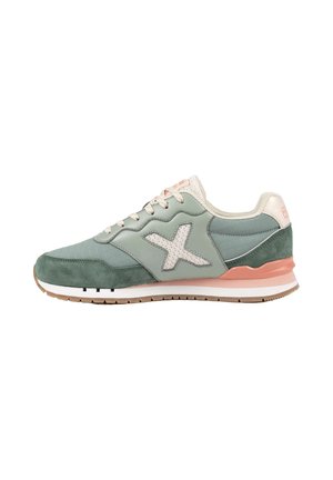 Zapatilla deportiva de caña baja en verde y melocotón con cordones blancos, logo lateral texturizado, suela acolchada y suela de goma para mejor agarre.