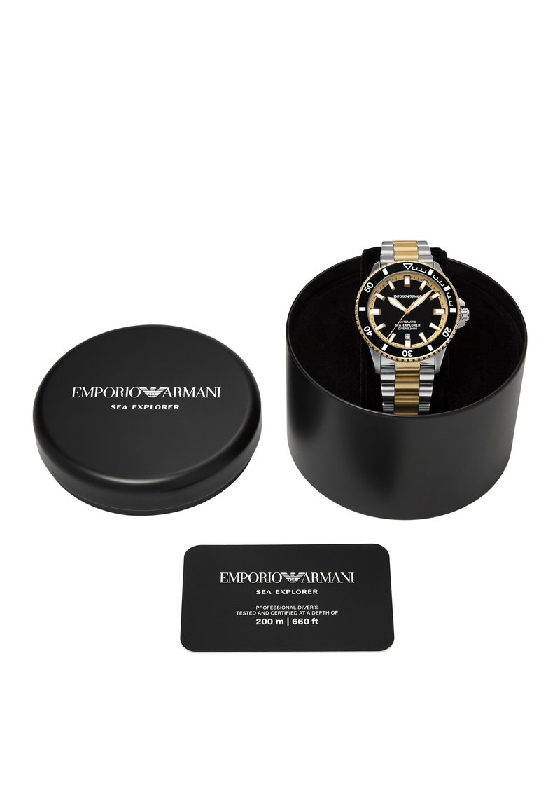 Svart armbandsur i rund klockkapsel med guld accenter, svart urtavla, vita timmarkörer och en matchande svart låda. Inkluderar ett certifikat.