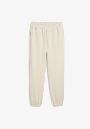 Jogging beige Puma en tissu doux, avec une taille élastique et des chevilles resserrées. Détail du logo subtil sur le côté.