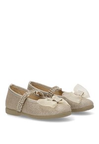 Bailarinas en tejido de brillo beige con puntera redondeada, tira elástica, detalle de lazo texturizado y suela de goma flexible.