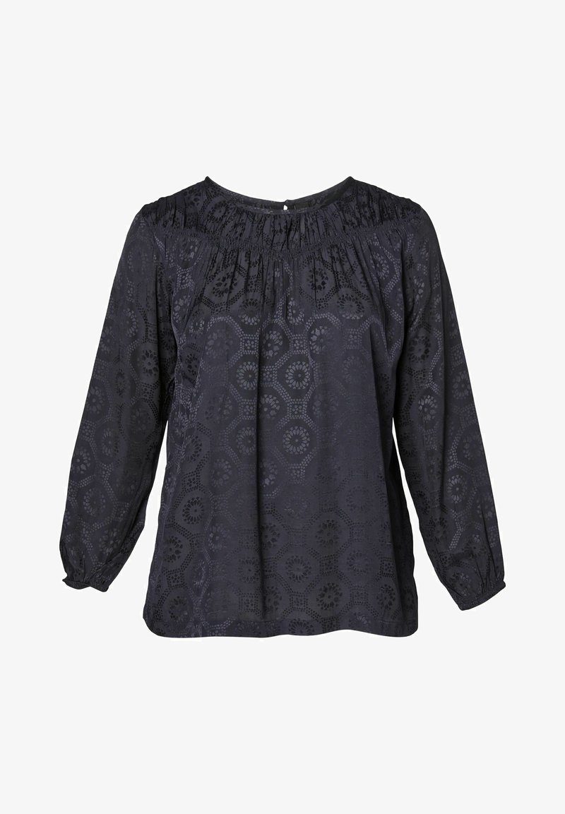 Tumman sininen pusero, jossa on pyöreä kaula-aukko, pitkät hihat ja kokoontumista. Kangas on hexagonimuotoista kuviointia, jossa on kukkaleikkauksia.