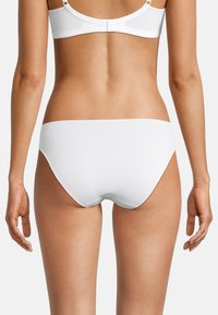 Mutande bianche in cotone con una trama liscia e un design a vita bassa, caratterizzate da un taglio senza cuciture in vita e uno stile minimalista.