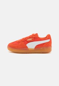 Narančasti sued sneakers s bijelim naglascima i mrežastim panelima. Zaobljeni vrh i gumeni potplat. Sadrži vezanje na vezice i Puma logotip.