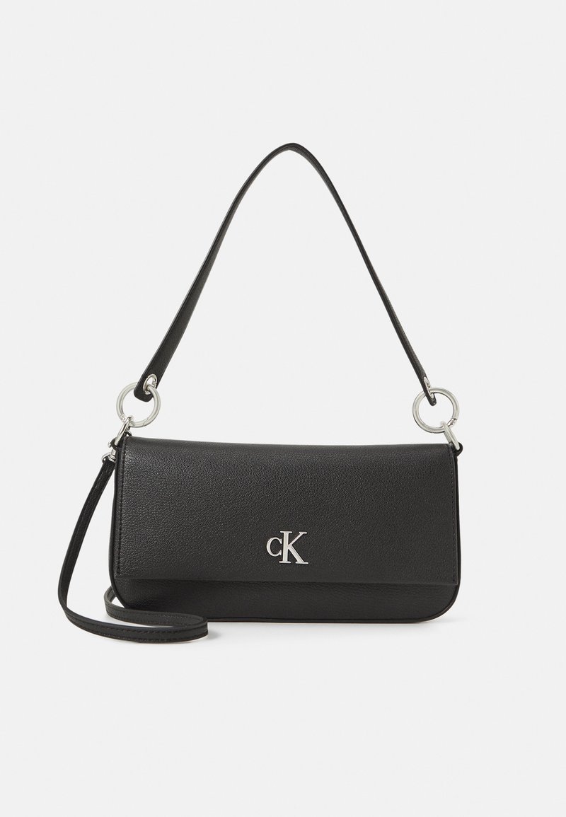 Borsa a tracolla in pelle nera con un design rettangolare elegante. Presenta un logo "cK" in argento, una lunga tracolla e dettagli in metallo.