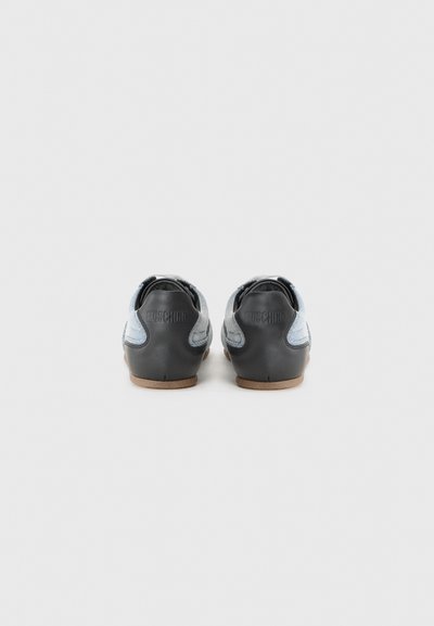 Black and blue sneakers with textured fabric and smooth heel. Features a rubber sole and embossed logo on the back. Rounded shape.