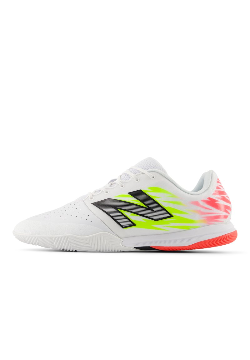 Zapatilla deportiva blanca con un upper texturizado, presenta una marca negra, acentos en verde neón y rosa, y una suela de goma acanalada para mayor agarre.
