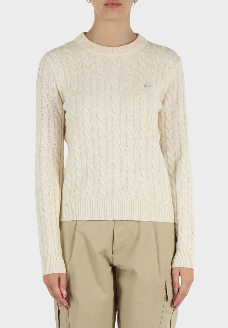 Maglione crema a trecce con scollatura rotonda e polsini a costine. Caratterizzato da un sottile logo sul petto. Texture morbida e forma aderente.