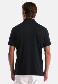 Marineblauw polo shirt met korte mouwen, klassieke kraag en een gladde textuur, gezien vanuit de achterkant. Eenvoudig ontwerp zonder zichtbare logo's of patronen.