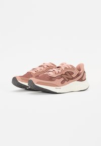 Løpesko i nyanser av rosa og brunt, med en mesh-overdel, teksturerte detaljer og en tykk såle i hvitt og svart med "FRESH FOAM."