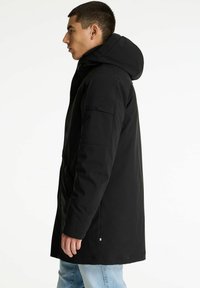 Zwarte capuchonparka met een ritssluiting, zijzakken en een slanke silhouet. Gemaakt van een soepele stof, met een subtiele logo-detail.