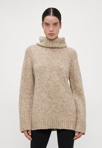 Beige gebreide trui met een col, met een losse pasvorm en een geribde zoom. Zachte textuur met subtiele kleurvariaties overal.