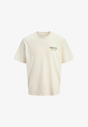 Χαμογελαστός νεαρός αγόρι που φοράει μαύρο φούτερ με φερμουάρ, λευκό πουκάμισο, ξεβάμμένα τζιν σορτς, λευκές κάλτσες και μπεζ παπούτσια με κορδόνια, στέκεται σε απλό φόντο.