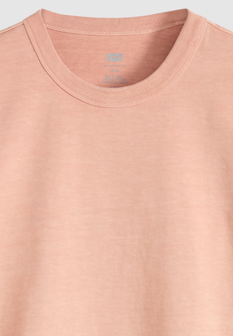 Hellrosa T-Shirt mit Rundhalsausschnitt, geripptem Kragen und innen im Halsausschnitt aufgedrucktem Levi's Markenetikett.