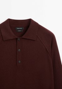 Bordeaux wol polo shirt met een klassieke kraag, drie zwarte knopen en een zachte brei-textuur met raglanmouwen. Etiket zichtbaar.