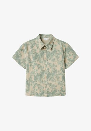 Chemise à manches courtes en beige clair avec un motif de feuilles tropicales vertes. Dotée d'une fermeture à boutons et d'un col classique.