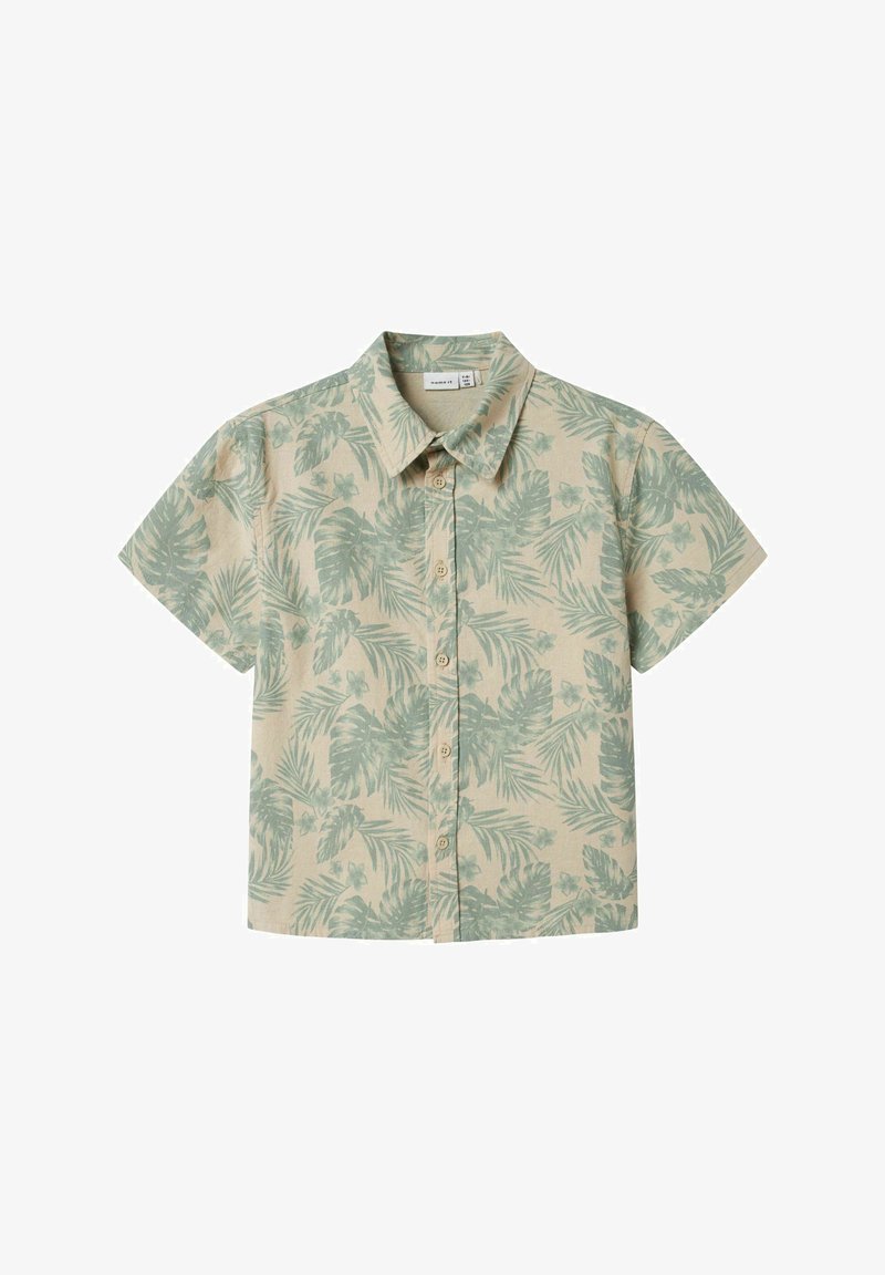 Šviesiai béžinė trumpomis rankovėmis marškinėliai su žaliu tropiniu lapų raštu. Su mygtukų priekyje ir klasikinio apykaklės dizainu.