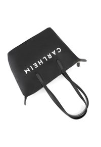 Czarna torba na ramię z dwoma długimi, teksturowanymi uchwytami oraz zamkiem błyskawicznym, z wyraźnym, białym nadrukiem logo z jednej strony.