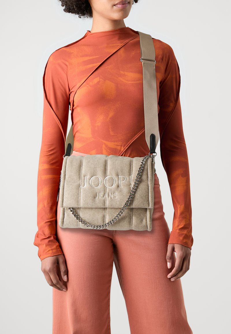 Borsa beige trapuntata con tracolla a catena e logo "JOOP! JEANS" embossato. Il materiale sembra morbido con una texture simile alla pelle scamosciata.